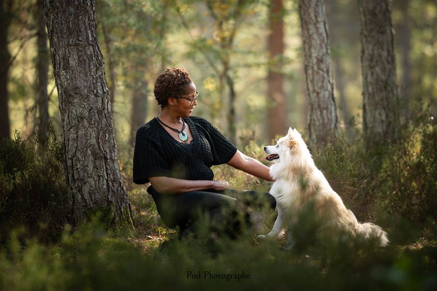 Elmina assise en forêt avec son chien